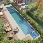 Vista aérea da piscina adulto e infantil do Residencial Dona Ivone Lara, com deck, espreguiçadeiras e jardins